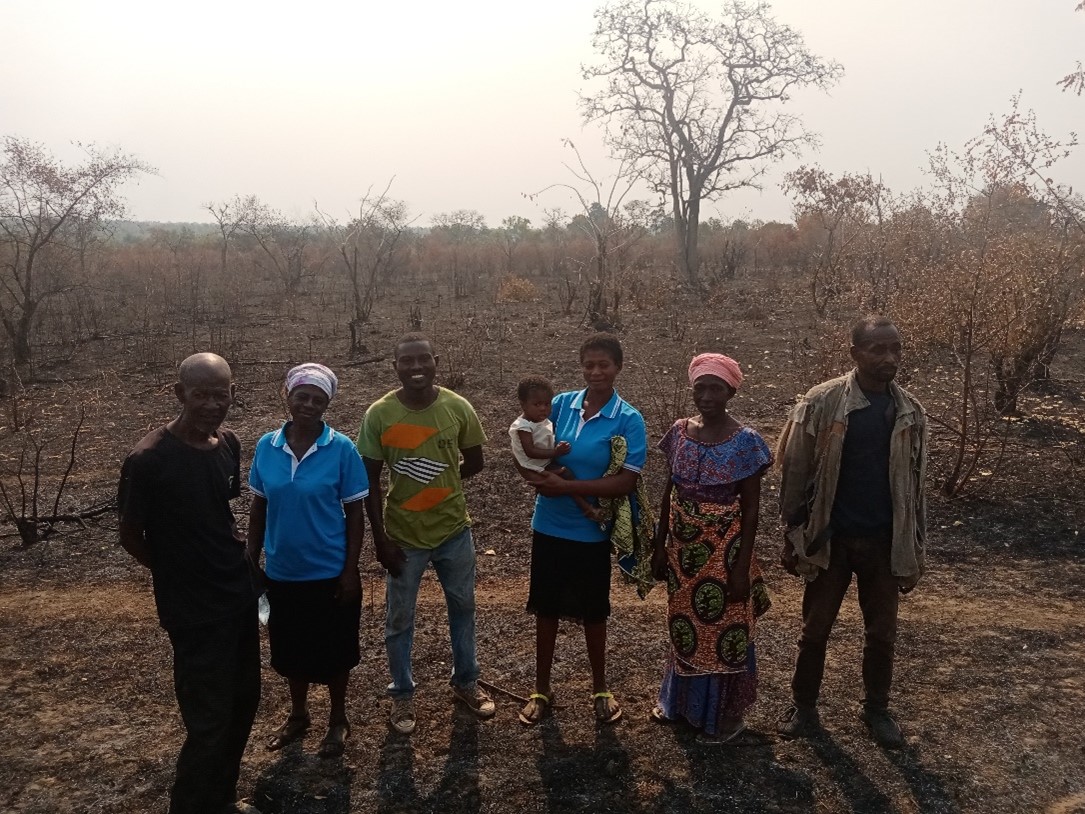 A group standing on dry, sparsely vegetated land