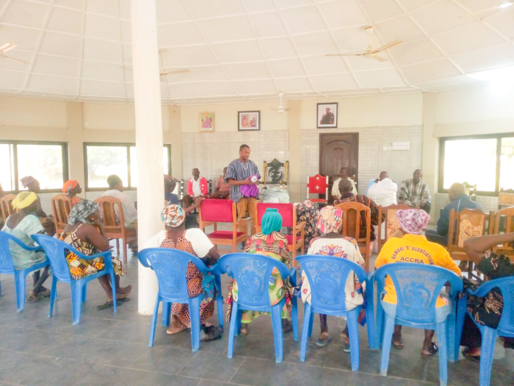 Community members seated in a hall during a meeting